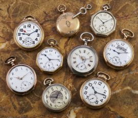Collection of antique and vintage pocket watches displayed on marble surface at Schiller Park Jewelry Coins & Collectibles